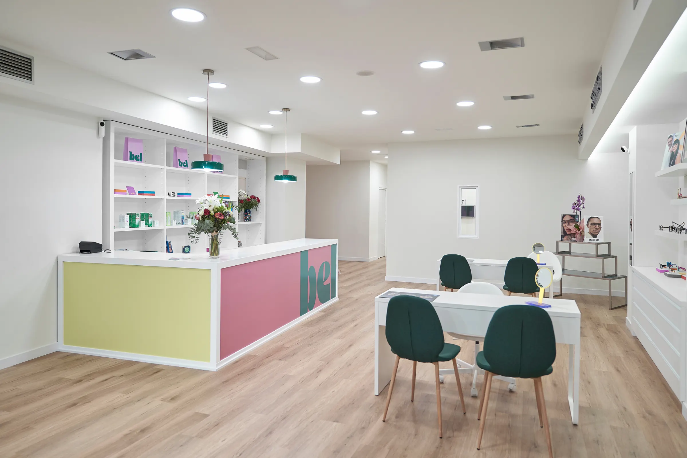 Interior do centro BEL en Monforte de Lemos: mostrador rosa e amarelo co logo e mesas de atención